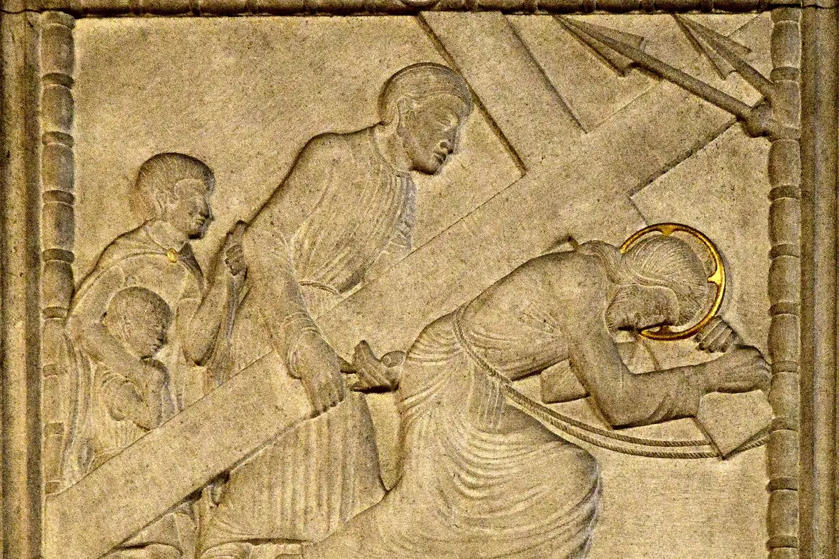 A limestone relief of Simon of Cyrene helping Jesus to carry the cross, one of the fourteen Stations of the Cross carved by Eric Gill.